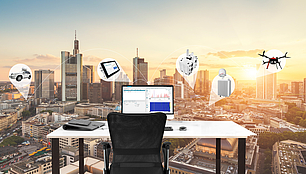 LS OBSERVER Spectrum Monitoring and RF Data Storage Office desk overlooking a city skyline with icons representing LS OBSERVER spectrum monitoring and RF data collection
