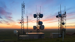 Radio Network Planning Tools Radio towers at sunrise representing software tools for planning and optimizing wireless networks.