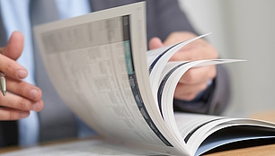 SPECTRUM News Magazine Person browses a printed magazine, representing industry news, insights and SPECTRUM publications